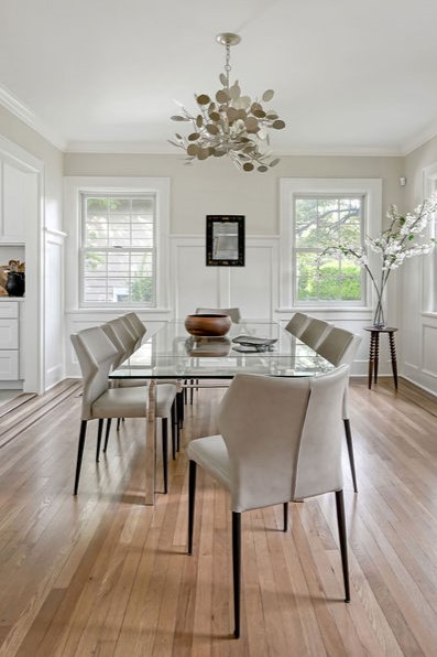 Dining room with wood dining table, classic chandelier, and bright window views in a Scarsdale residence.