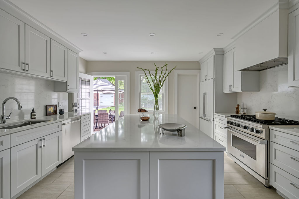 Centered kitchen island view showcasing symmetrical cabinetry and warm, inviting staging.
