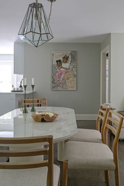 Open dining space staged by Orlie Katsiris Staging & Interiors featuring a wood dining table, upholstered chairs, sculptural pendant lighting, and cohesive neutral decor.
