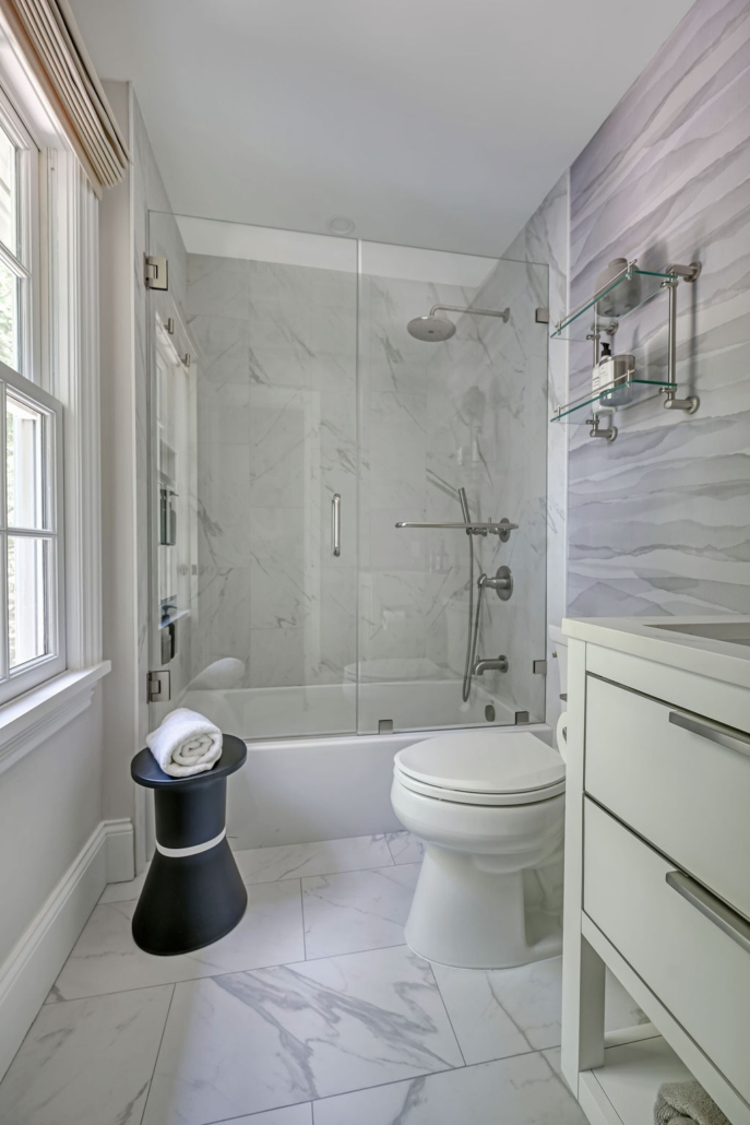 Minimalist, contemporary and urban penthouse interior home office design by Orlie Katsiris Staging & Interiors featuring modern furniture, a black standing desk, white ergonomic chair, and a gray geometric area rug