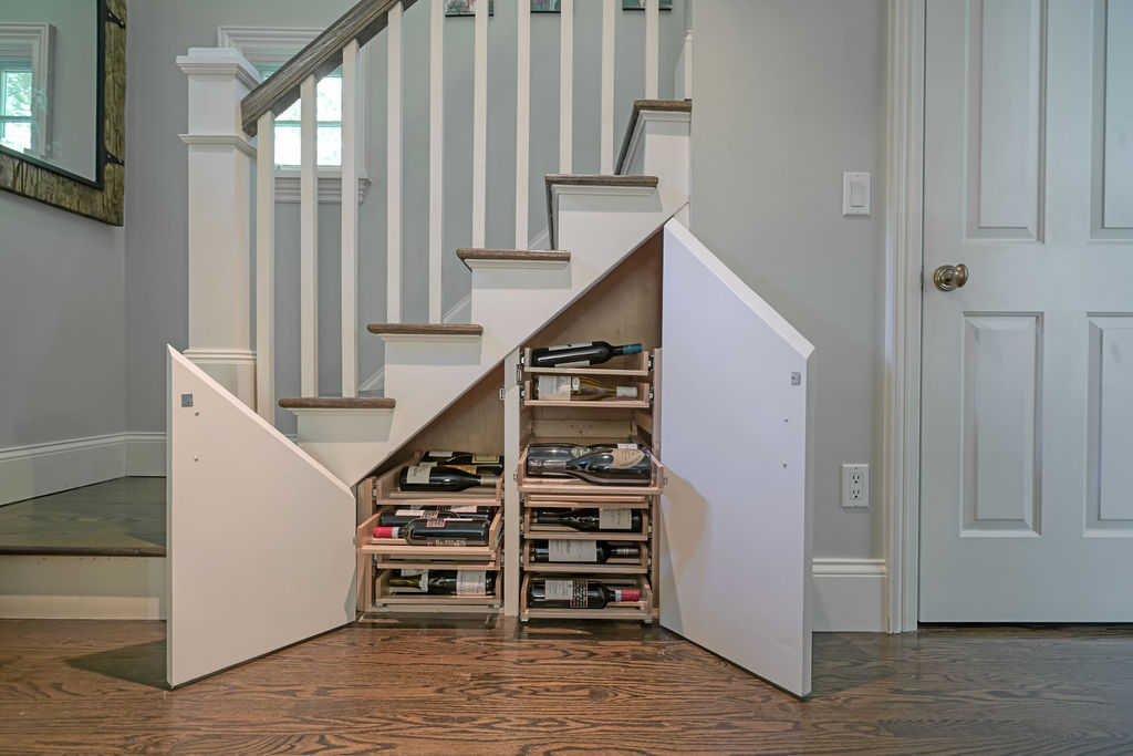 Under-stair wine cellar staged by Orlie Katsiris Staging & Interiors showcasing custom shelving and compact storage design.