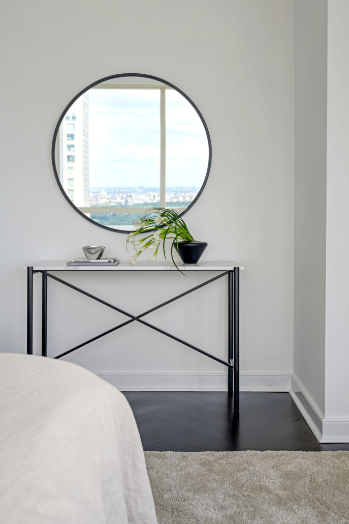 Minimalist, contemporary and urban penthouse interior home office design by Orlie Katsiris Staging & Interiors featuring modern furniture, a black standing desk, white ergonomic chair, and a gray geometric area rug